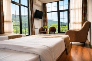 a hotel room with two beds and a large window at Madin Eco Hotel in Debed