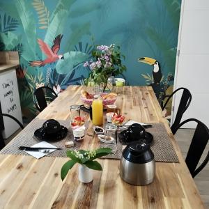 a wooden table with food and drinks on it at Chalet La Bachole - Chambre d'hôtes in Charancieu