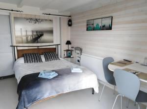 a bedroom with a bed and a desk and two chairs at Chalet La Bachole - Chambre d'hôtes in Charancieu