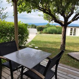 a table and two chairs on a patio at Chalet La Bachole - Chambre d'hôtes in Charancieu