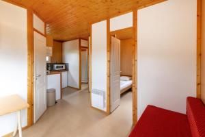a small room with a bed and a kitchen at Camping l'Estela sur le GR70 in Le Monastier sur Gazeille +10 photos