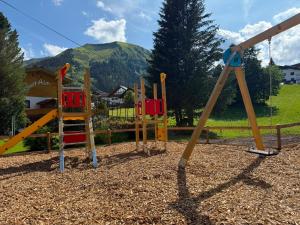 a park with a playground with a mountain in the background at Almtraum Berwang in Berwang