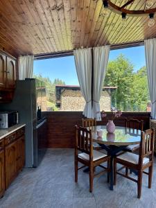 a kitchen with a table and chairs and a large window at The Heaven Sibiu in Sebeşu de Sus +21 photos