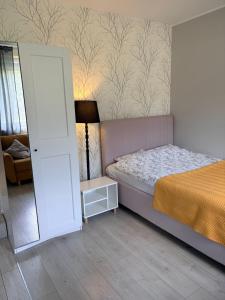a small bedroom with a bed and a lamp at Apartament COMFORT Centrum in Krotoszyn