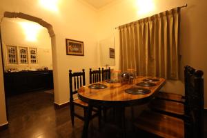 a dining room with a wooden table and chairs at Princess Bungalow Stay Madurai in Tirupparangunram +52 photos