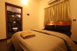 a bedroom with a bed with a towel on it at Princess Bungalow Stay Madurai in Tirupparangunram