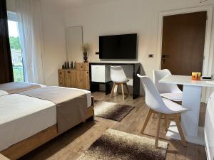 a bedroom with a bed and a table and a television at Mosaic Guesthouse in Lin