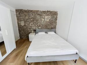 a bed in a room with a stone wall at Third Corner in Liège