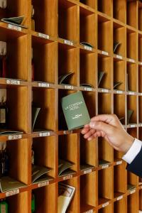 a person holding a book in a wine rack at Hotel La Costiera in Varcaturo