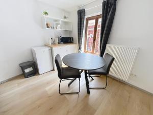 a kitchen with a table and chairs in a room at Third Corner in Liège