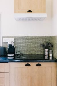 a kitchen with a black counter top in a kitchen at L'Antre-neuf - 9p, piscine, arrivée autonome, wifi in Fontaine-Milon