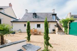 a house with a courtyard with a table and chairs at L'Antre-neuf - 9p, piscine, arrivée autonome, wifi in Fontaine-Milon