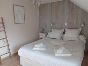 a bedroom with a large white bed with towels on it at Le Som' des Pyrénées in Luz-Saint-Sauveur