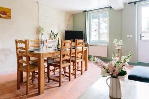 a dining room with a wooden table and chairs at L'Antre-neuf - 9p, piscine, arrivée autonome, wifi in Fontaine-Milon