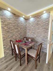 a dining room with a table and chairs and a brick wall at Charming Apartment with balcony in Vidin