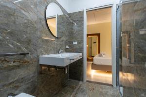 a bathroom with a sink and a mirror at The Reserve by Vulcano in Mirto +34 photos