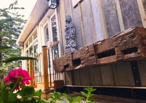 a porch of a house with a gate and a pink flower at Peterborough Zen Retreat in Peterborough