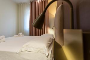 a bedroom with a bed with a lamp next to a window at The Reserve by Vulcano in Mirto