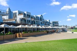 a building with a row of umbrellas on a sidewalk at Atlantic Port 9 in Bloubergstrand
