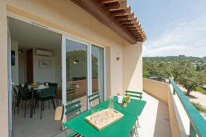 a balcony with a green table and chairs at Versants - La Croix Valmer in La Croix-Valmer