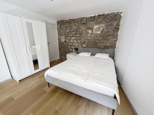 a bedroom with a bed with a stone wall at Third Corner in Liège