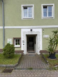 a green building with a door and a building at Wohnhaus Leitner in Wald am Schoberpaß
