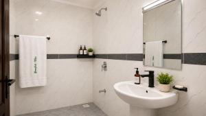 a white bathroom with a sink and a mirror at Greenfield Villa M- Diani Beach in Ukunda +4 photos