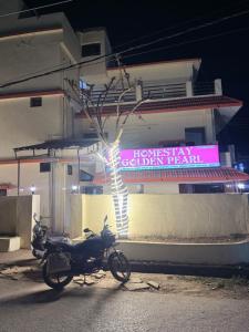 a motorcycle parked in front of a building with a sign at Hotel Golden Pearl in Rewa +12 photos