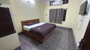 a bedroom with a bed and a television in it at Hotel Golden Pearl in Rewa