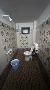 a bathroom with a toilet and a window at Hotel Golden Pearl in Rewa