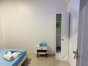 a bedroom with a bed and a table and a door at Twice Apartment in Hulhumale