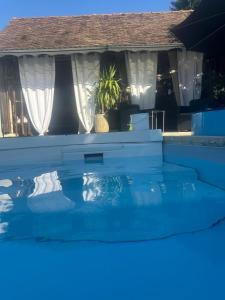 a swimming pool in front of a house at Les Poiriers Rouges in Mauchamps +2 photos