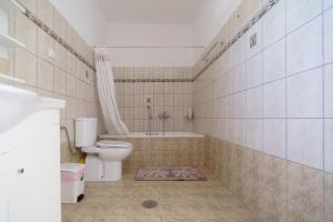 a bathroom with a toilet and a bath tub at Sagiada Anchor House in Sagiada +19 photos