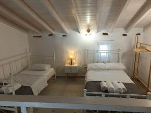 a bedroom with two beds and a table with a lamp at Annousio 's house in Dhriopís