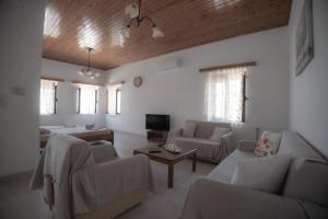 a living room with couches and a tv at Sagiada Anchor House in Sagiada