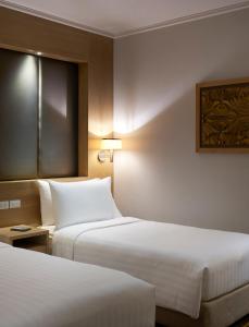 a hotel room with two beds and a window at Amari Bangkok in Bangkok