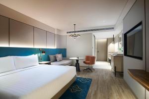 a bedroom with a bed and a living room at Amari Bangkok in Bangkok