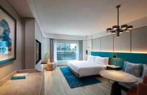 a hotel room with a bed and a table at Amari Bangkok in Bangkok