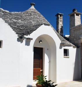 una casa blanca con techo y puerta en Il Trullo del viaggiatore, en Alberobello