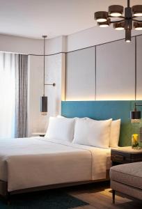 a bedroom with a large white bed and a couch at Amari Bangkok in Bangkok