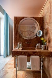 a bathroom with a sink and a large mirror at EGEO - Ortigia in Syracuse