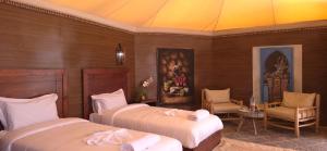 a bedroom with two beds and a painting on the wall at Sunset Agafay Resort in El Karia