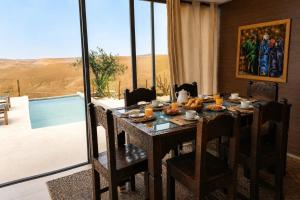 a dining room table with a view of the desert at Sunset Agafay Resort in El Karia
