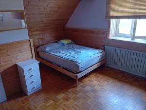 a small bedroom with a bed and a dresser at Planinski dom Hermanov Hram in Log pod Mangartom
