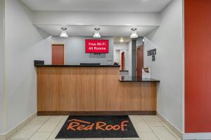 a red roof sign in a lobby with a red rock sign at Red Roof Inn Charlestown in Charlestown