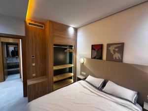 a bedroom with a large bed and a tv at la perle d'el jadida in El Jadida