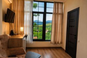 a room with a desk and a large window at Madin Eco Hotel in Debed