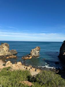 a view of the ocean with rocks in the water at el sahel residence in Beni Haoua +3 photos