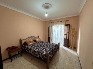 a bedroom with a bed and a window at el sahel residence in Beni Haoua