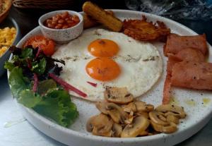 a plate of breakfast food with eggs and mushrooms at Pak Hospitality in Islamabad +12 photos